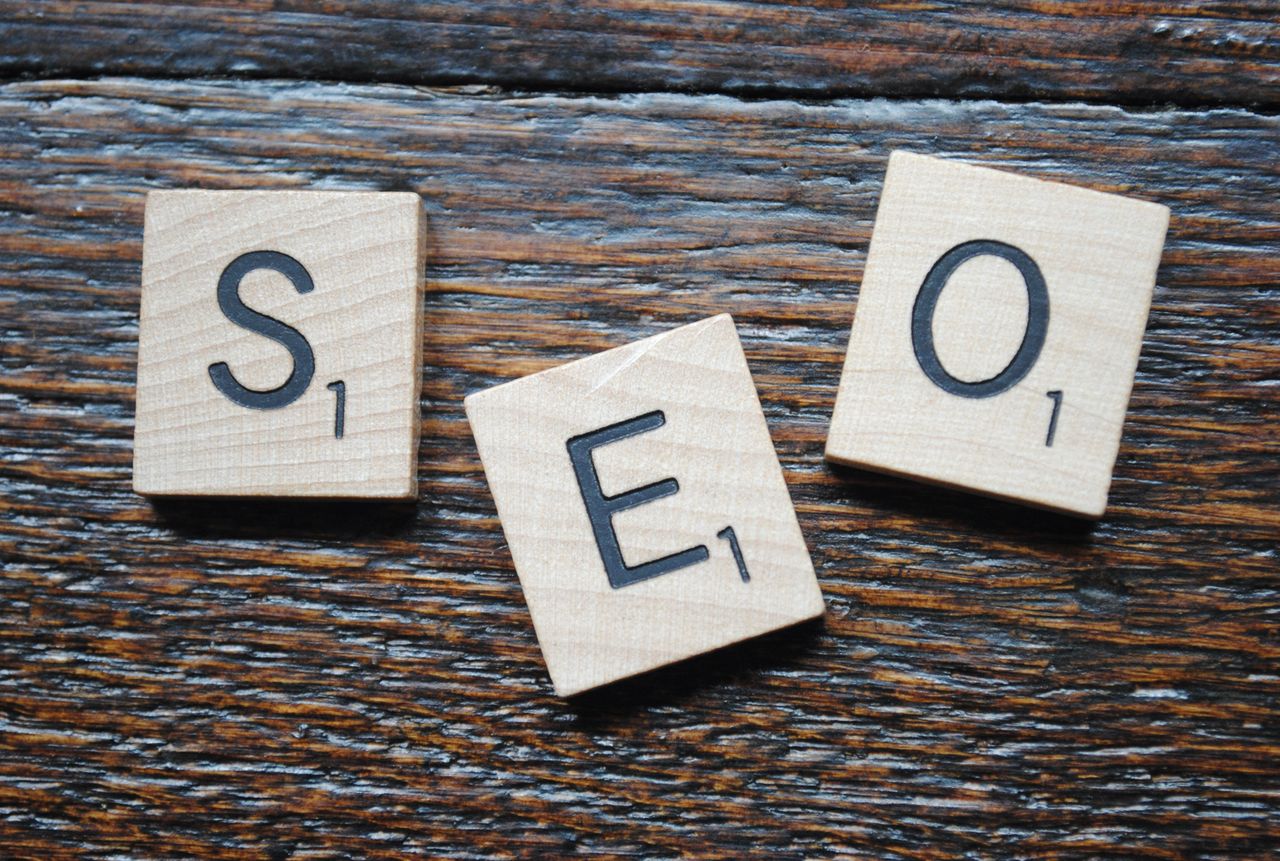services-04 Close-up of Scrabble tiles spelling SEO on a wooden table for content strategy.